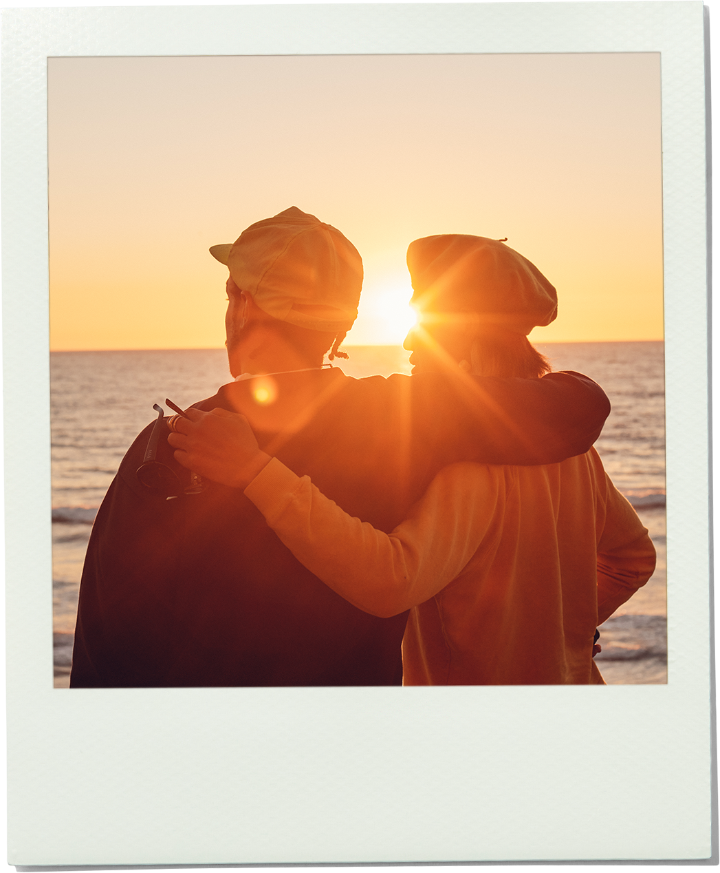 Two people embracing on a beach at sunset