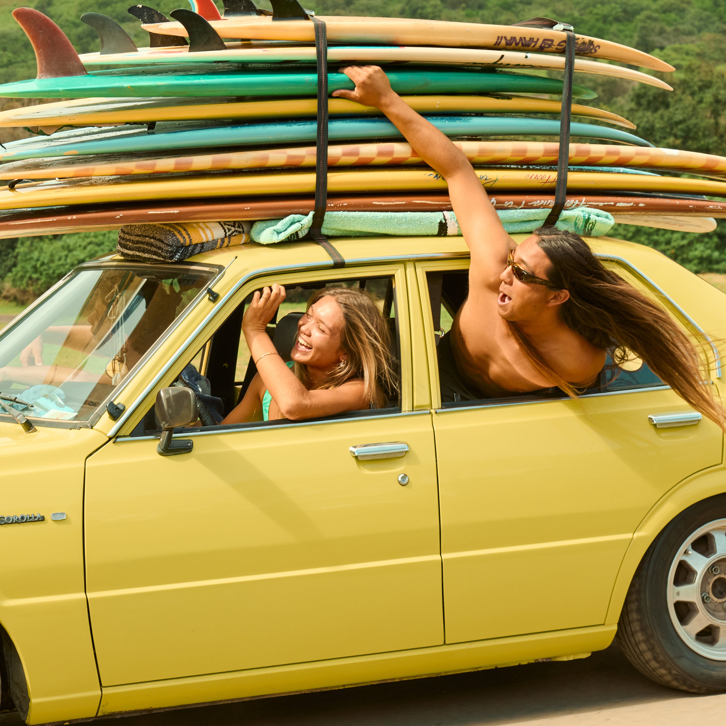 Friends cruising in a yellow car with surfboards stacked on top, embracing beach vibes and good times - Original SPF Collection - Sun Bum