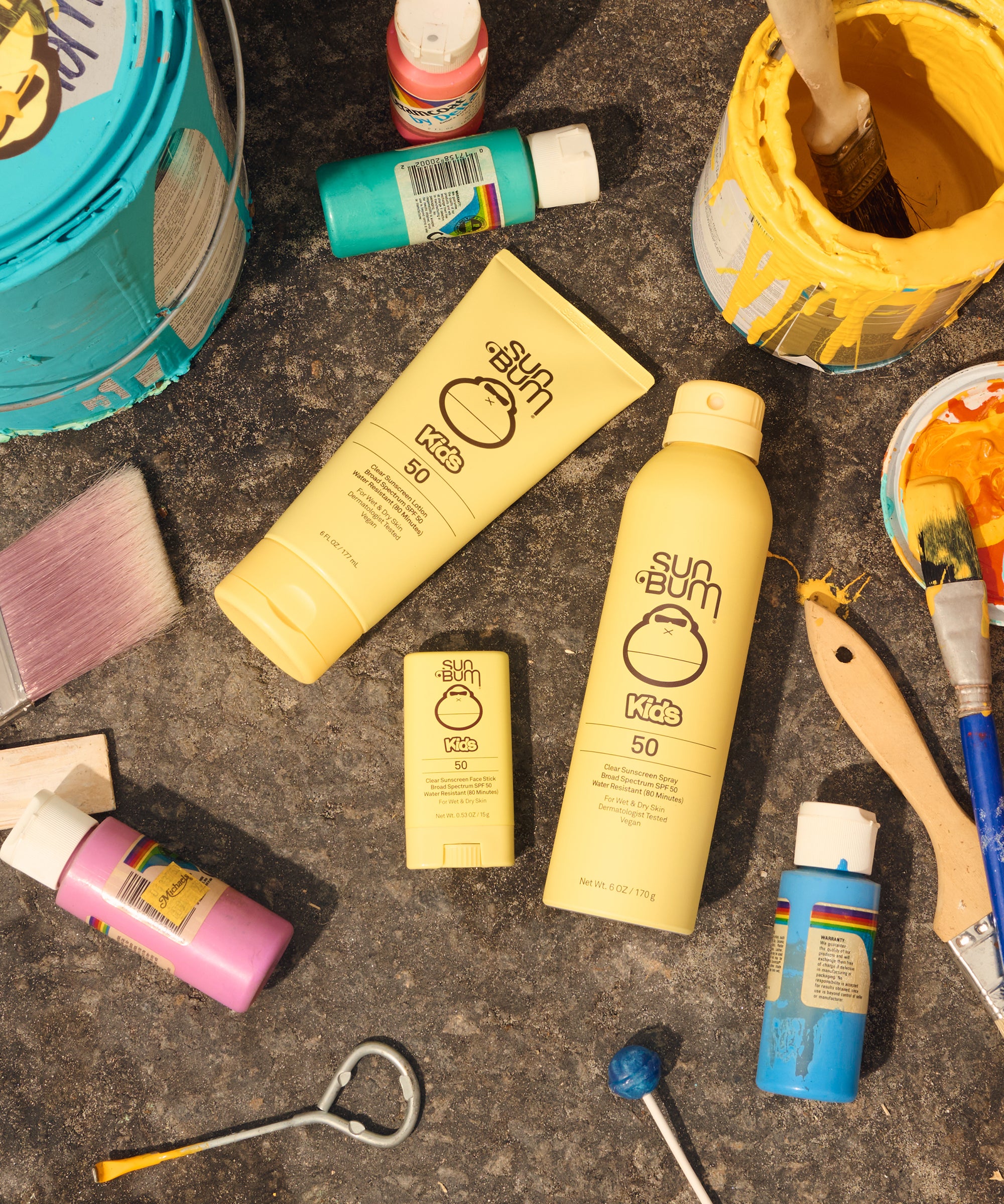 Kids SPF 50 Clear Sunscreen Spray in yellow tubes with paint cans and brushes by Sun Bum
