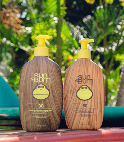 Sun Bum XL SPF 30 and 50 sunscreen pump bottles on a sunny day outdoors – XL Sunscreen Collection - Sun Bum.