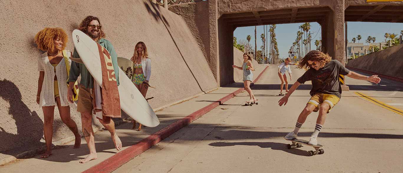 3 people on skateboards under a bridge
