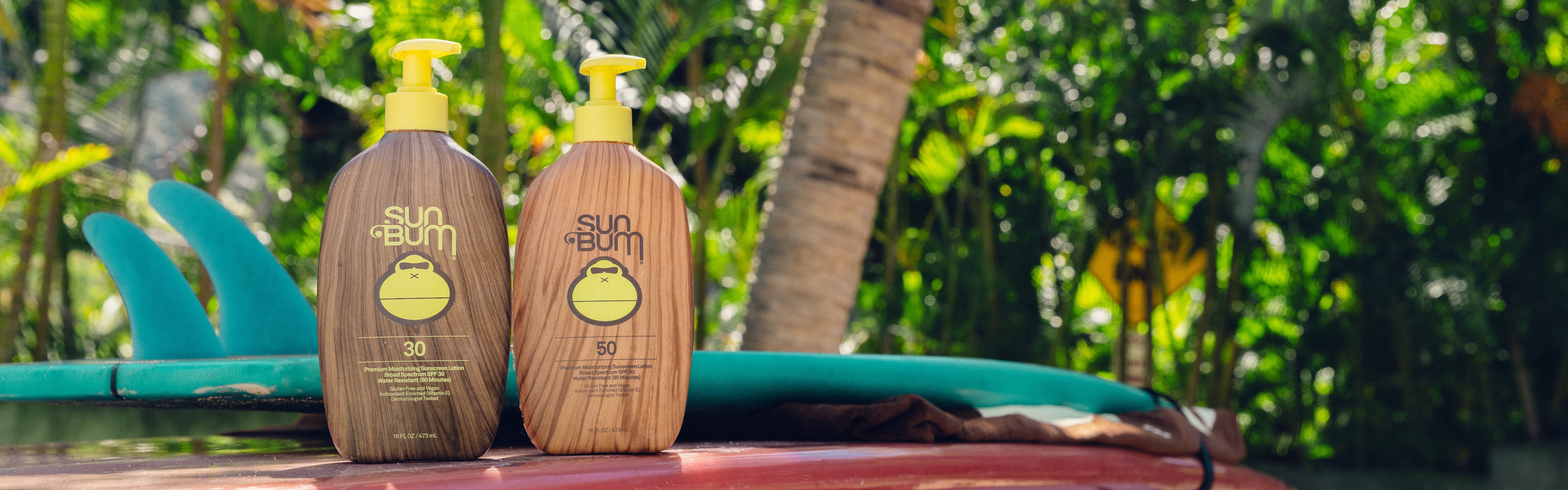 Sun Bum XL SPF 30 and 50 sunscreen pump bottles on a sunny day outdoors – XL Sunscreen Collection - Sun Bum.