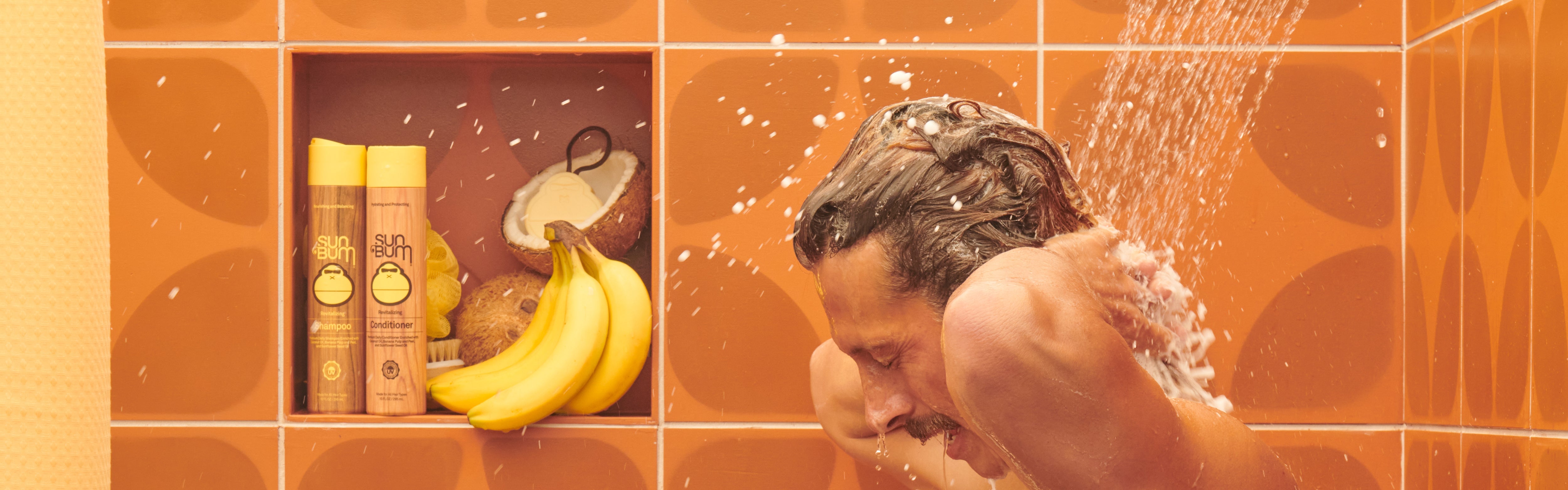 Man washing hair in a retro shower with Sun Bum Shampoo and Conditioner, part of the Shampoo and Conditioner Collection – Sun Bum.