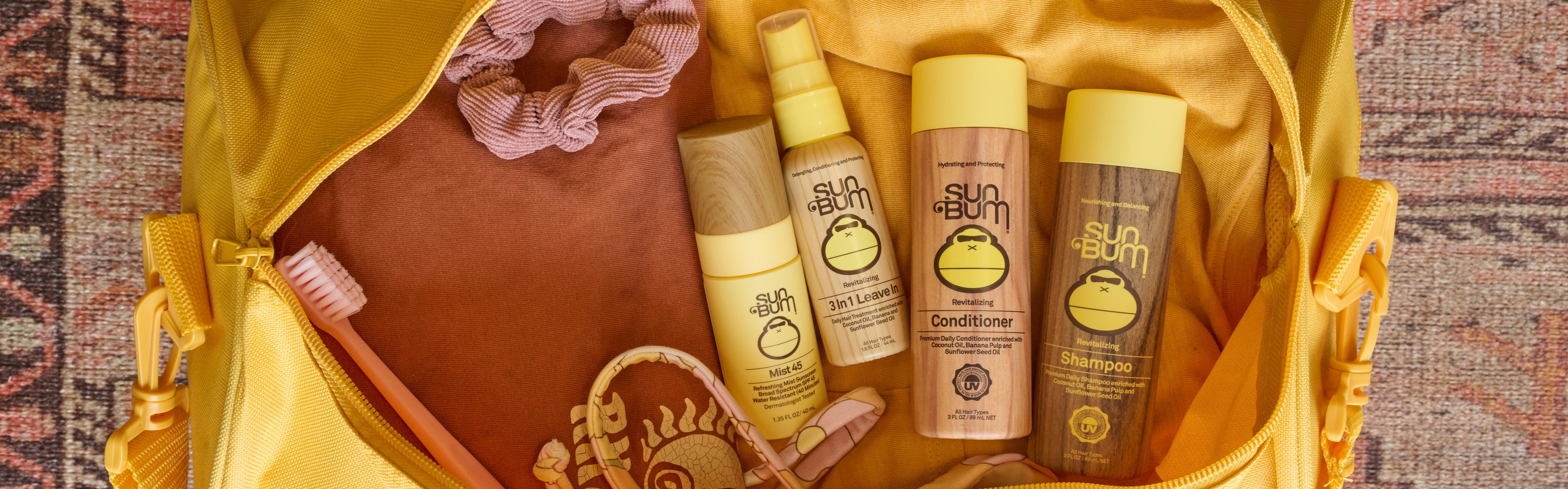 Sun Bum travel-sized hair and body products packed in a yellow bag, featuring the SB Travel Sized Products Collection – Sun Bum.