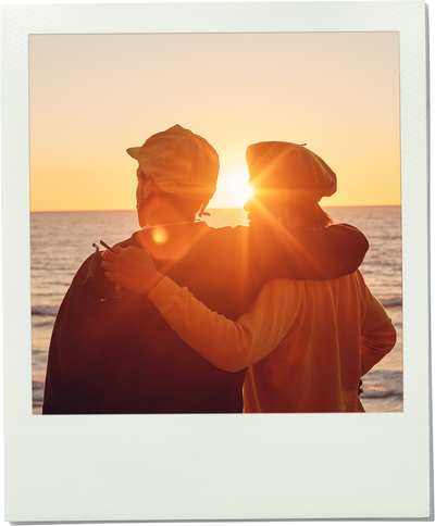 Two people embracing on a beach at sunset