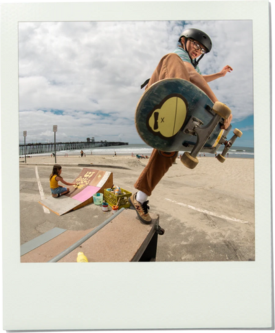 Skateboarder doing a trick with a Sonny sticker on the bottom of his skateboard