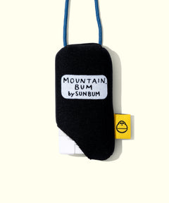 Black pouch with 'Mountain Bum by Sunbum' text and a yellow tag on a white background