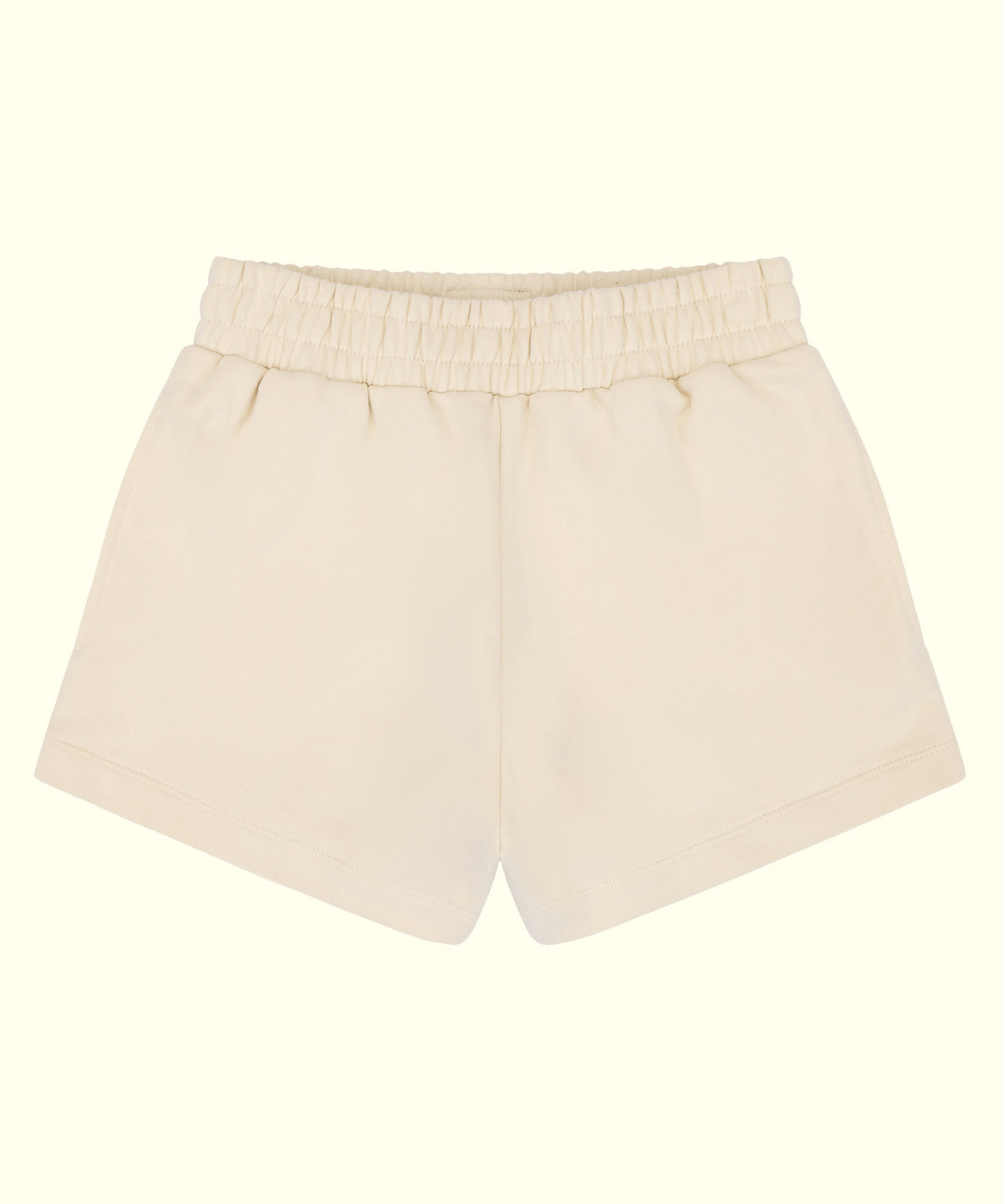 A pair of cream-colored cotton shorts with an elastic waistband, shown flat against a solid cream background.