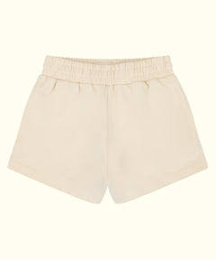 A pair of cream-colored cotton shorts with an elastic waistband, shown flat against a solid cream background.
