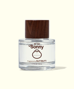 Clear bottle of 'Sonny' fragrance with a wooden cap on a white background