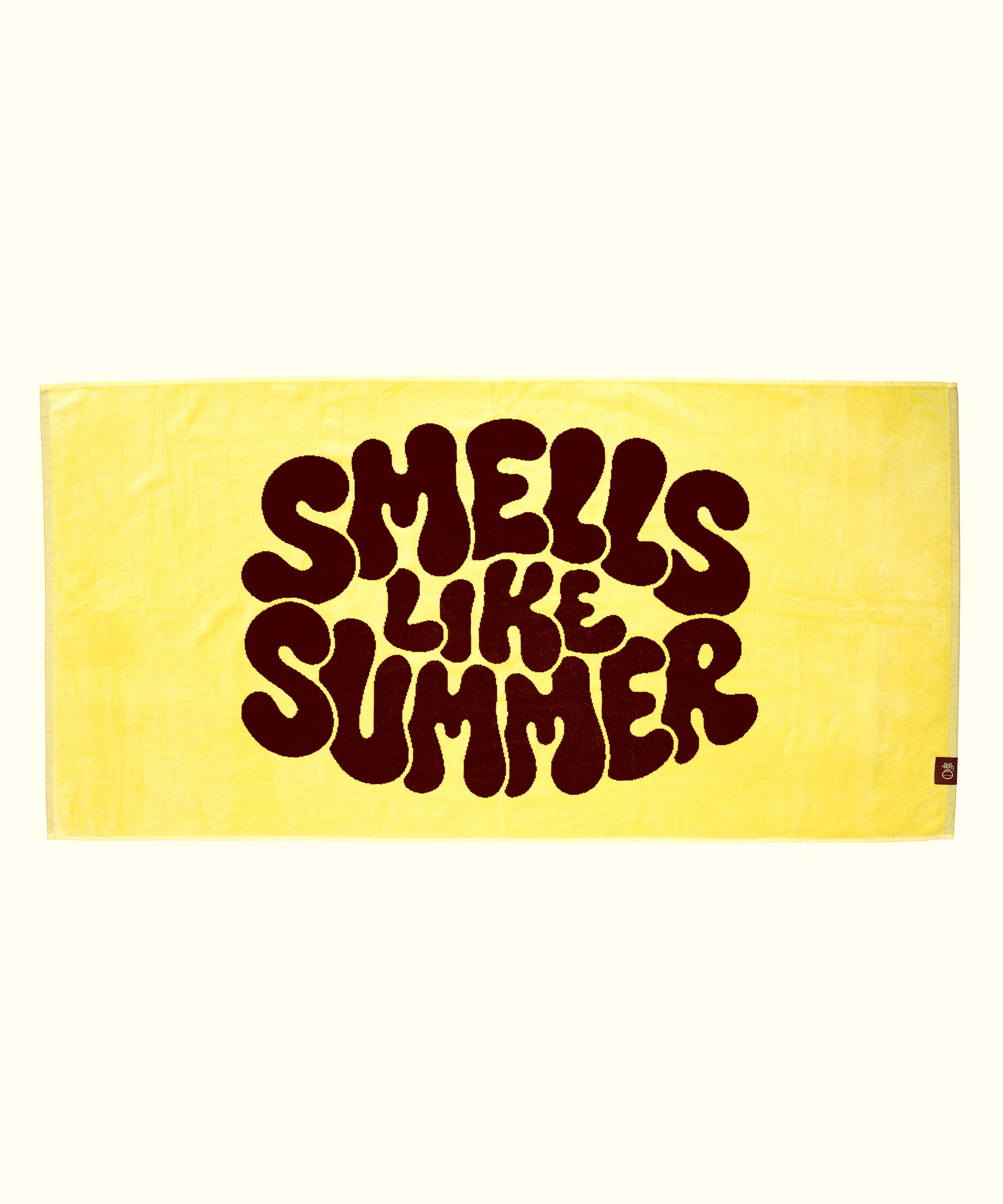 Yellow towel with 'Smells Like Summer' text on a white background