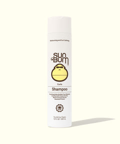 Curly Hair Shampoo - Front view of a white bottle of Curls Shampoo highlighting its ingredients and benefits for curly hair on a light background. The label features detailed product information. Sun Bum