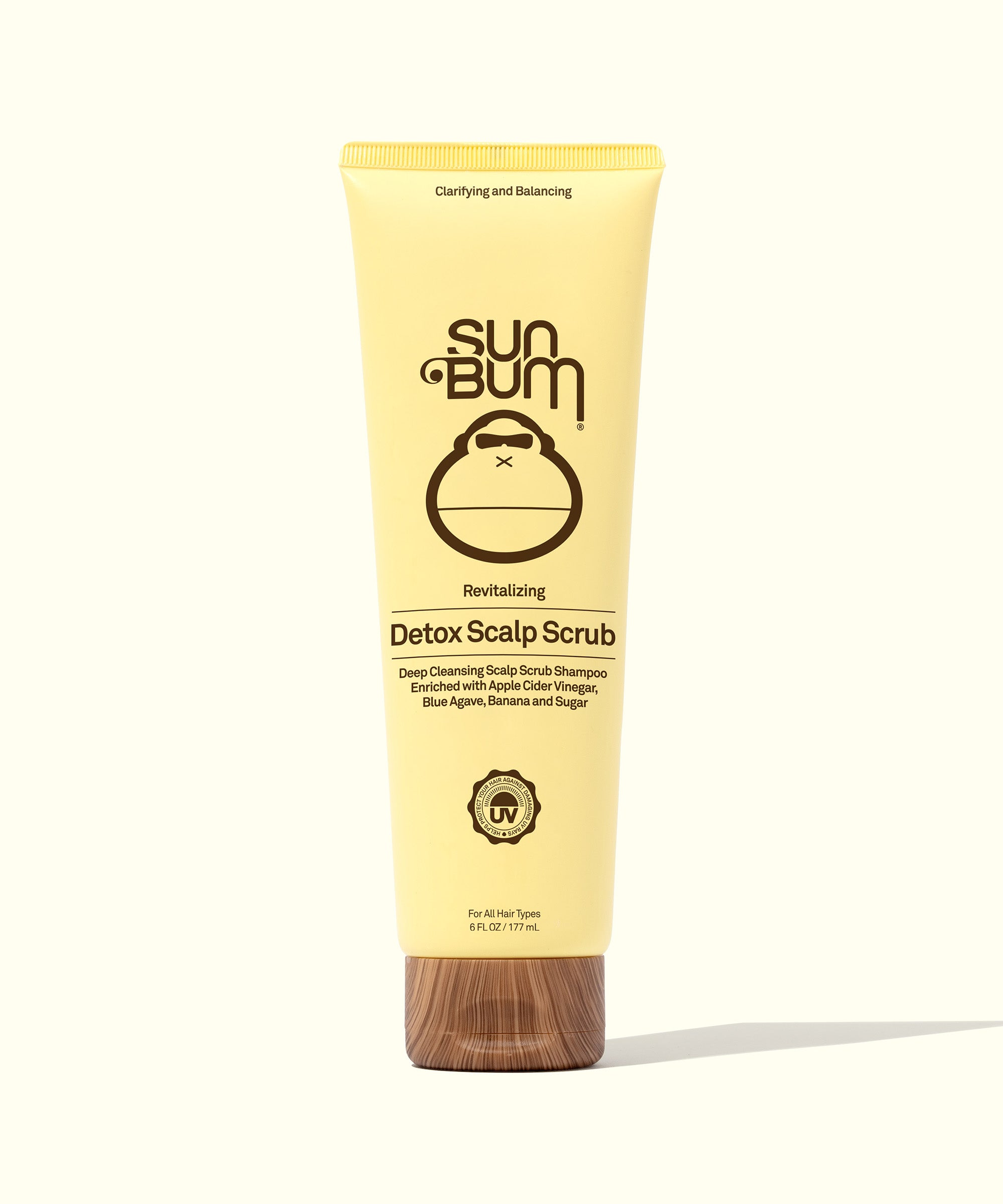 Yellow tube of Revitalizing Detox Scalp Scrub by Sun Bum, enriched with Apple Cider Vinegar, Sugar, and Blue Agave, designed to cleanse and exfoliate the scalp, breaking down product buildup, dirt, and excess oil.