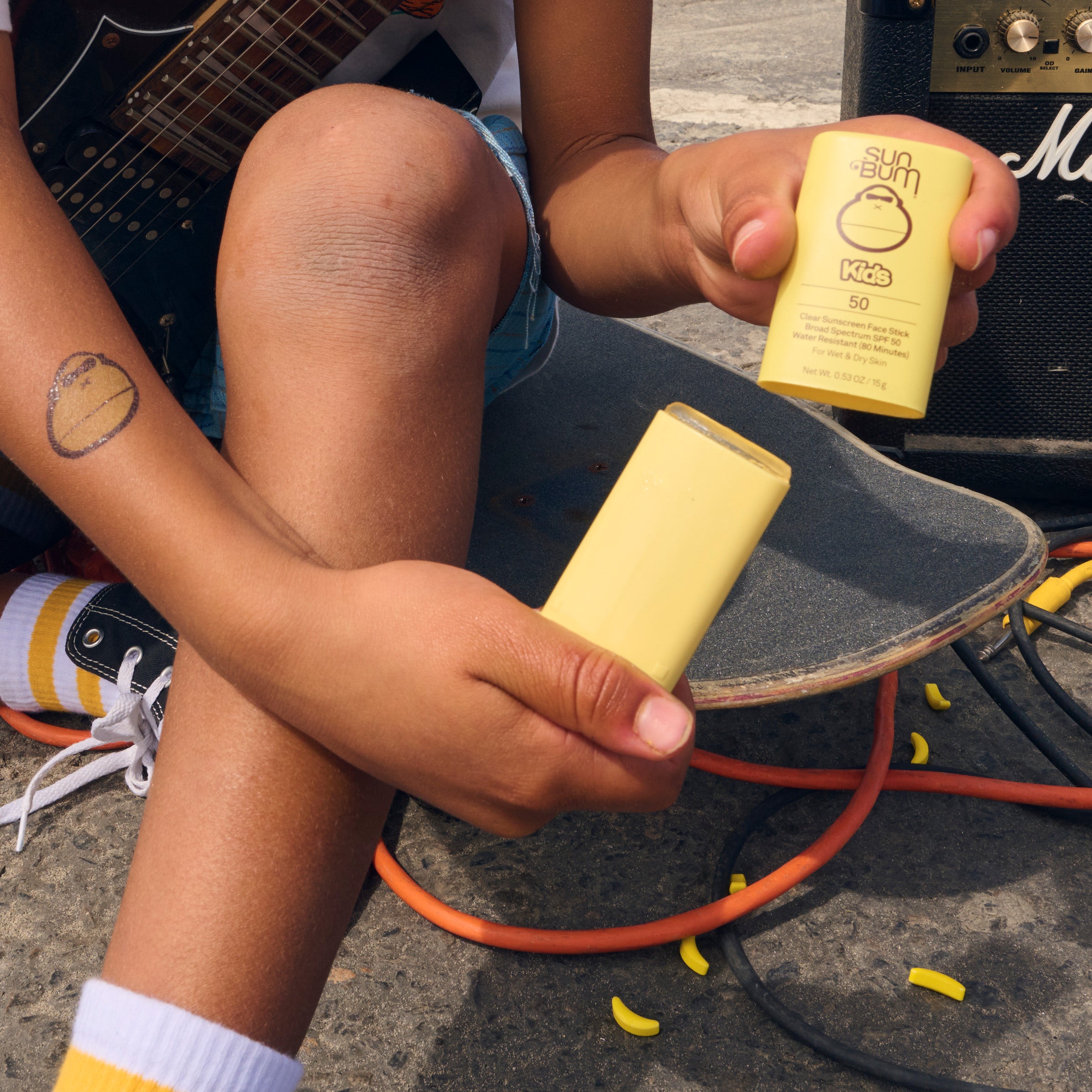 Kid holds SPF 50 Face Stick with a fresh banana scent, perfect for on-the-go sun protection – Kids Collection - Sun Bum