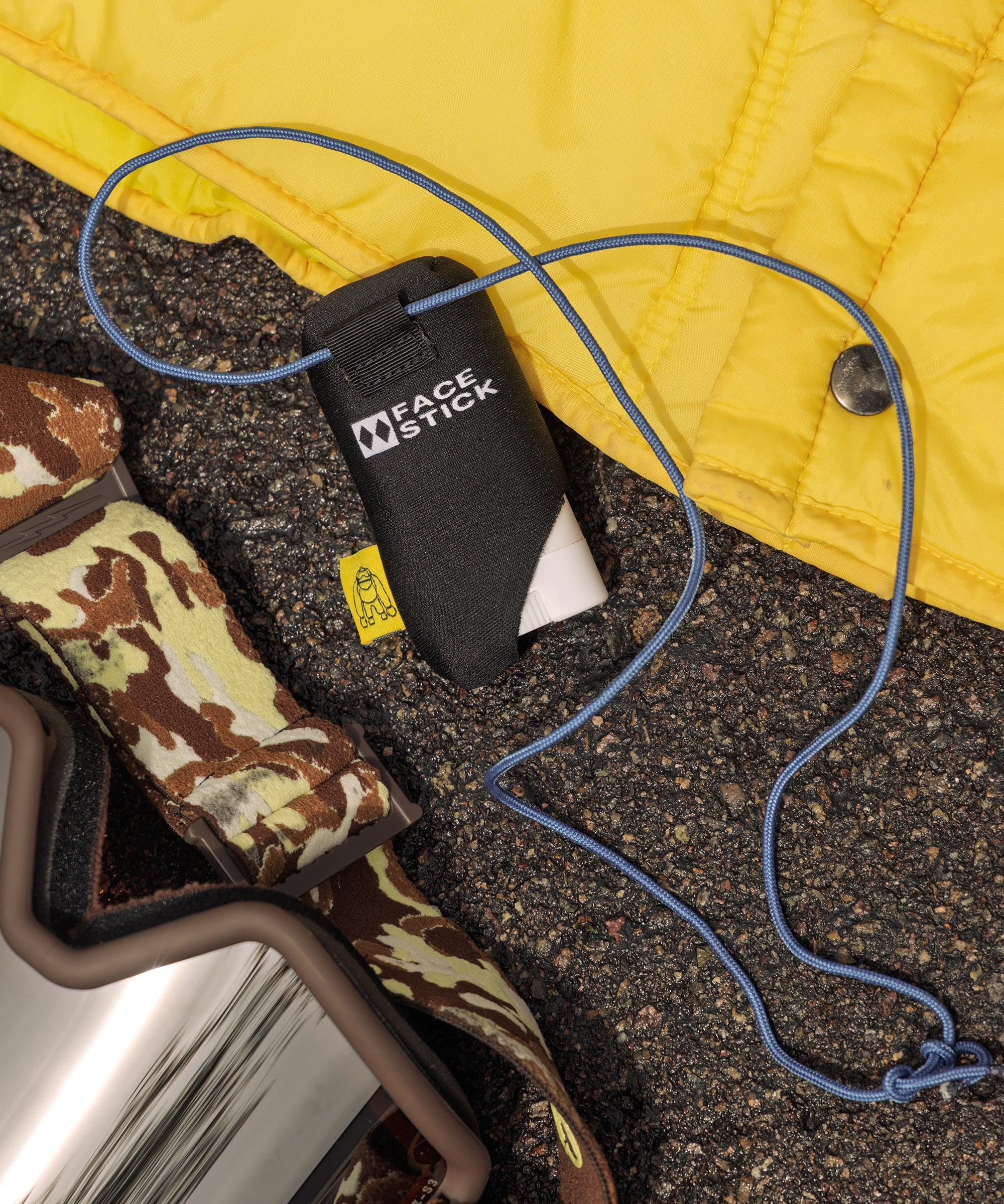 Face stick with camouflage strap on a textured surface