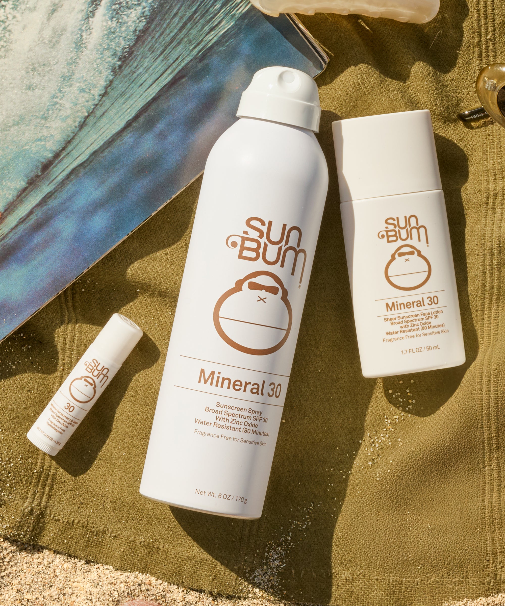 Sun Bum mineral sunscreen products on a sandy background