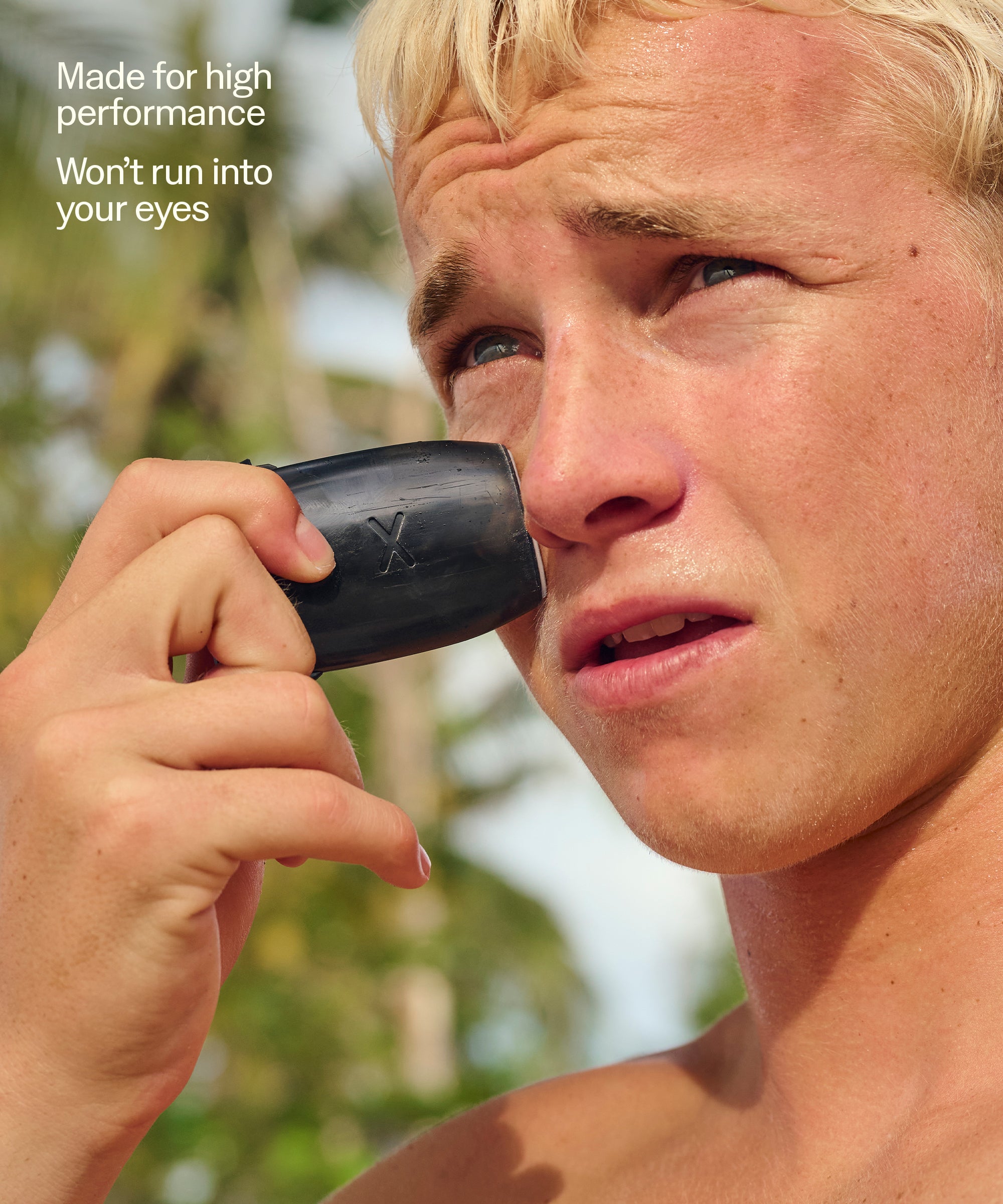 Person holding a black container to their eye with text about high performance and not running into eyes.