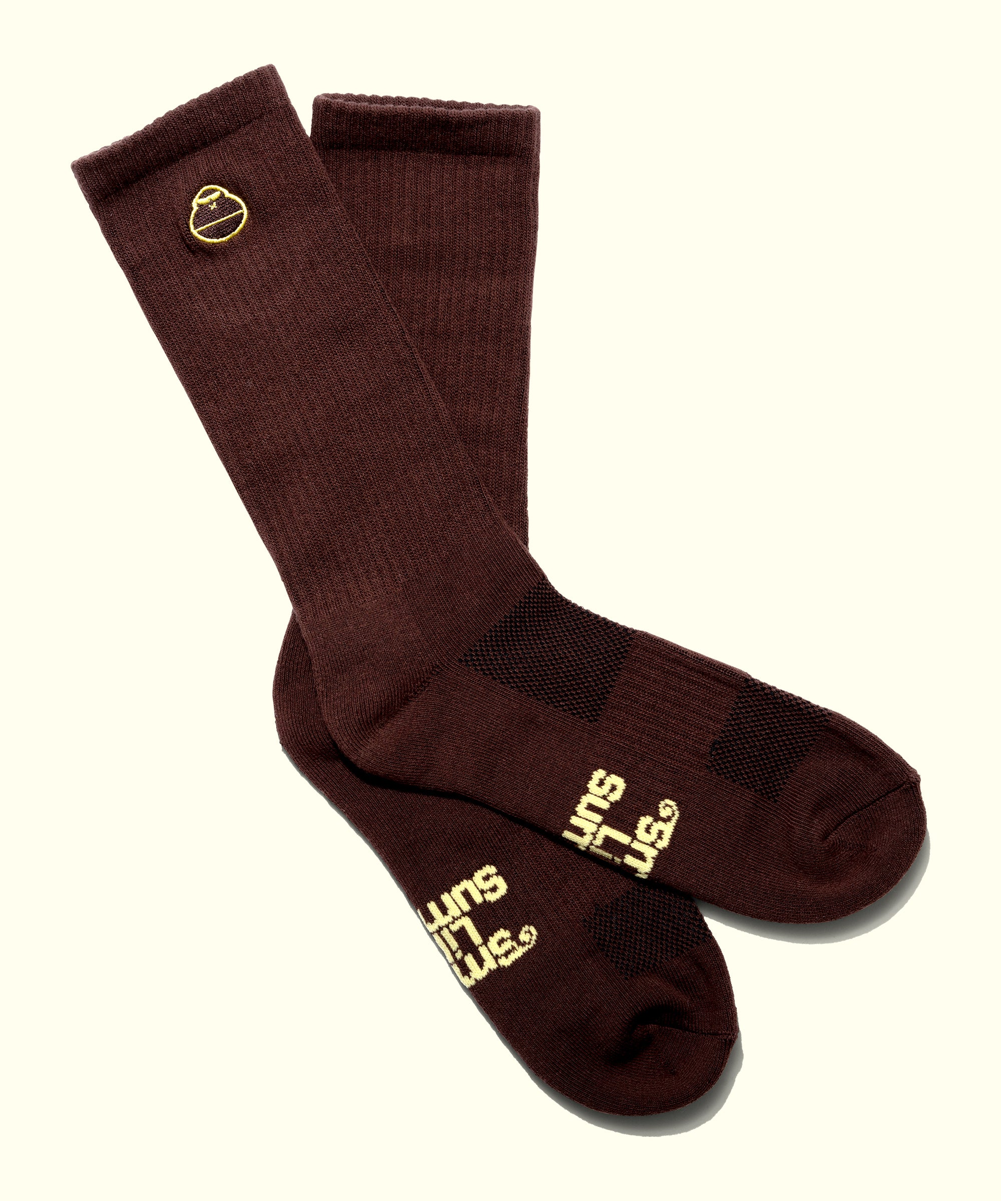 Pair of brown socks with yellow text on a white background