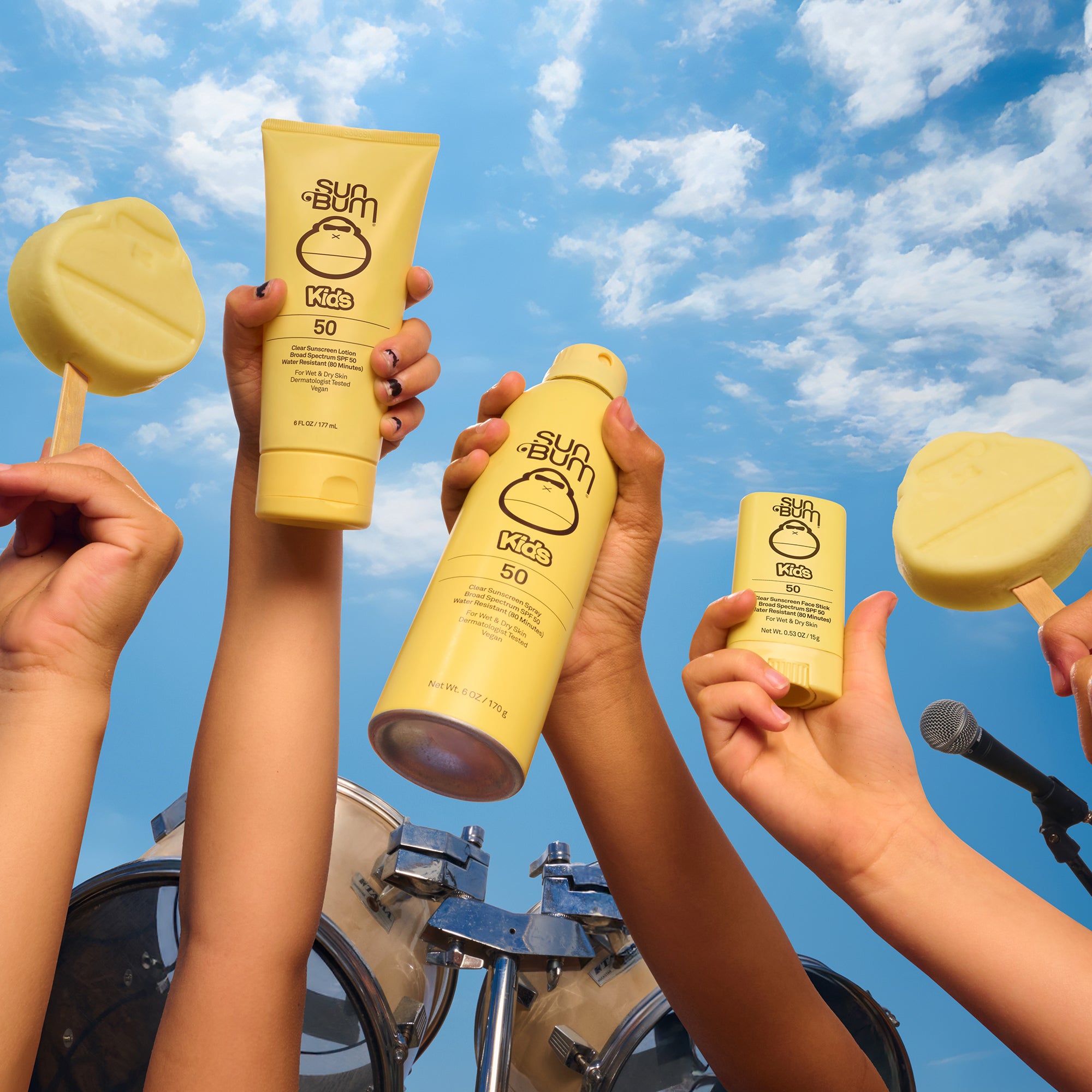 Kids holding up Sun Bum Kids sunscreen in the air along with Sonny popsicles 