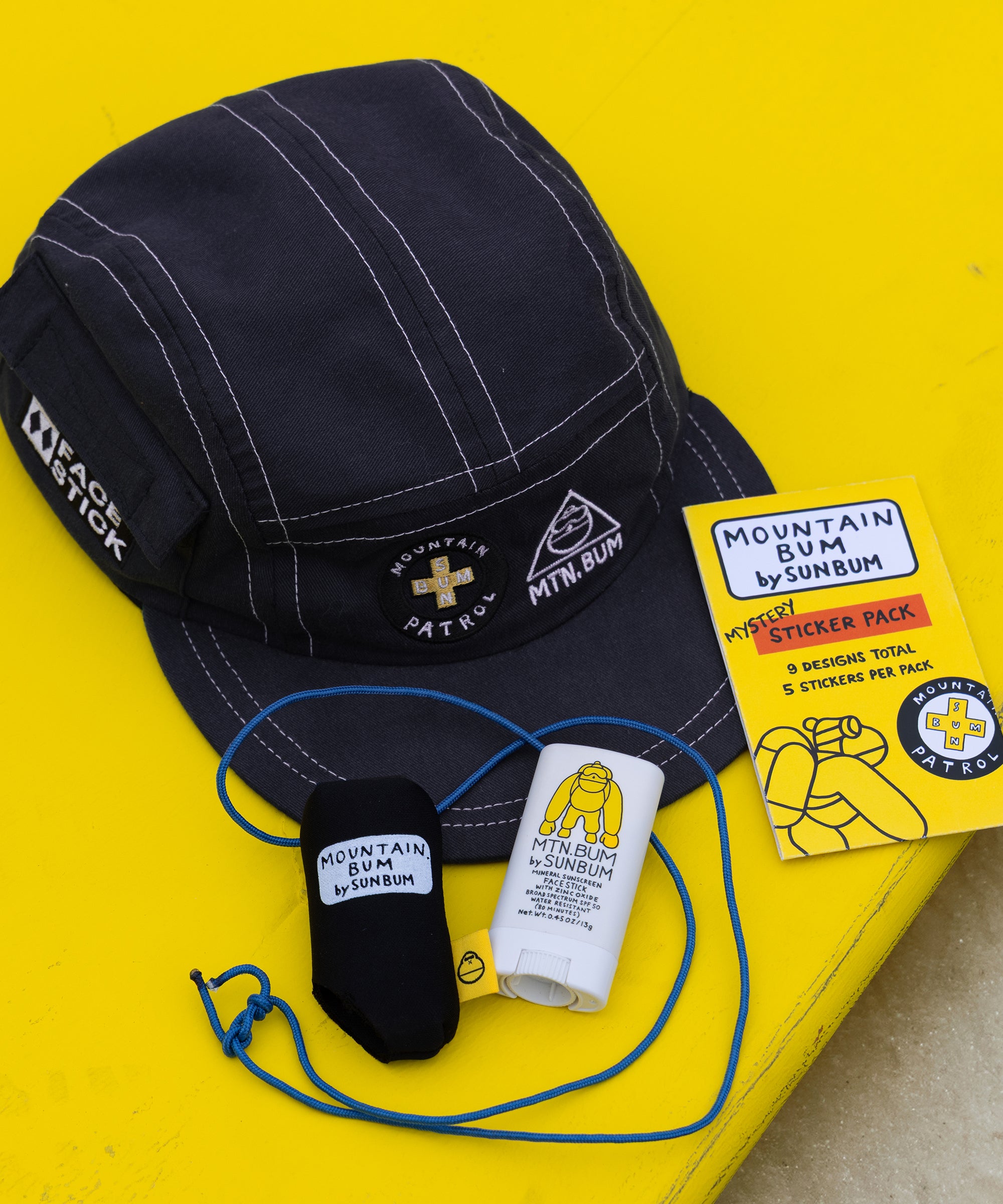Black cap, socks, and a sticker pack on a yellow background