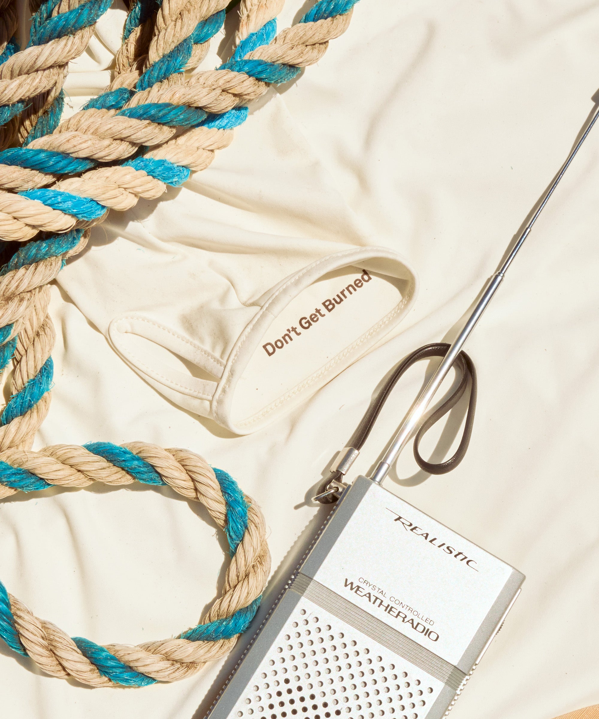 Rope, metal rod, and a product labeled 'Elastique' on a light background
