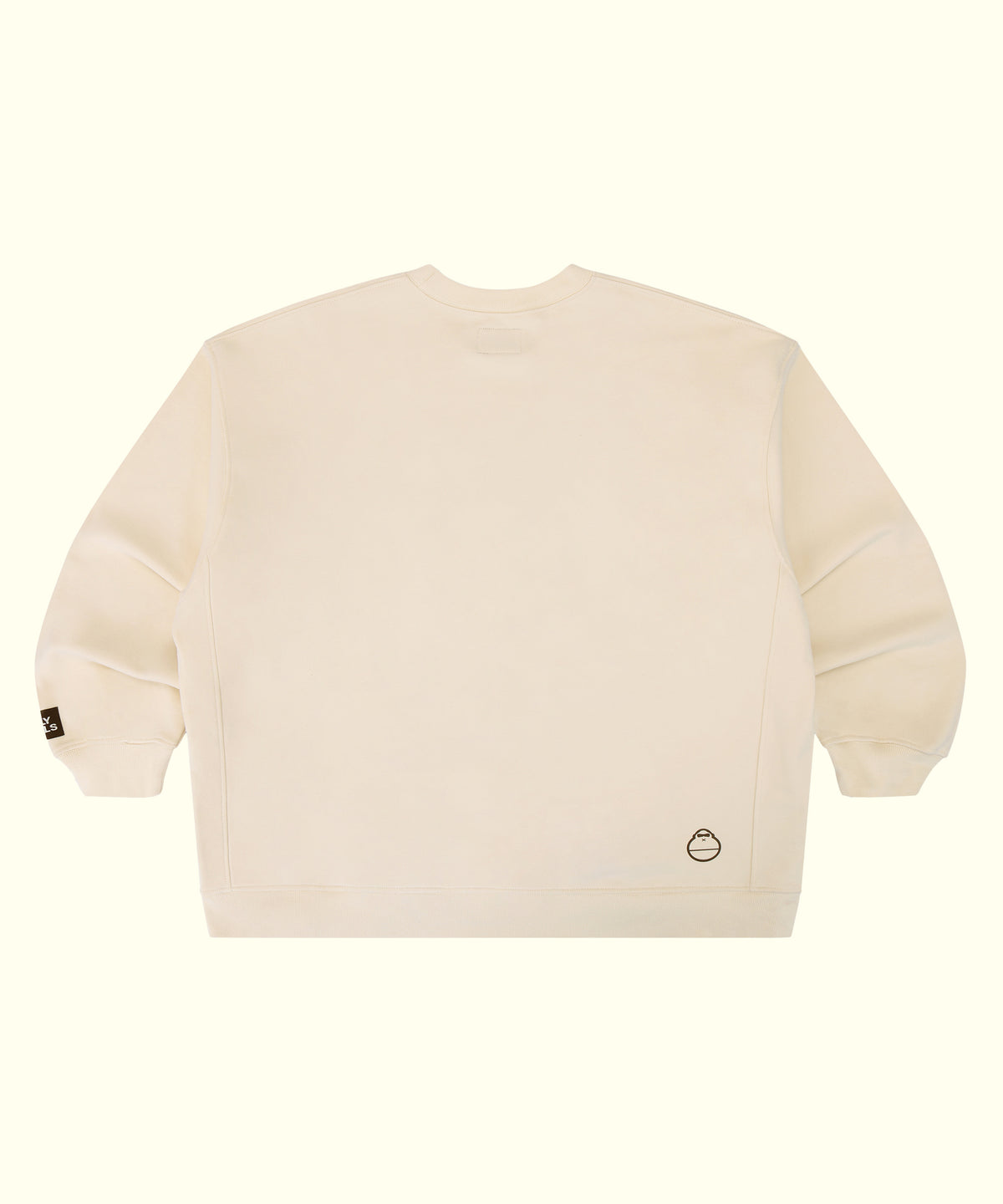 An off-white crewneck sweatshirt shown from the back, featuring a small circular logo on the lower right back and a small black tag on the left sleeve cuff, set against a solid cream background.