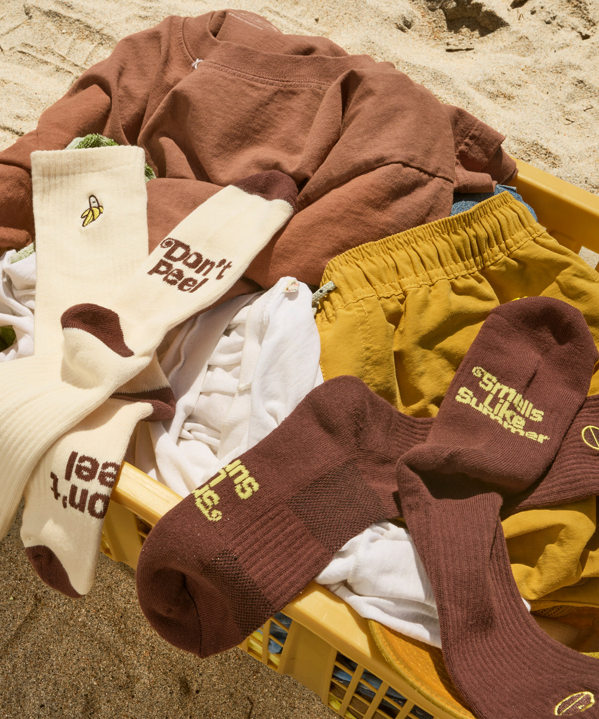 Brown and white socks in a laundry basket on the beach. 