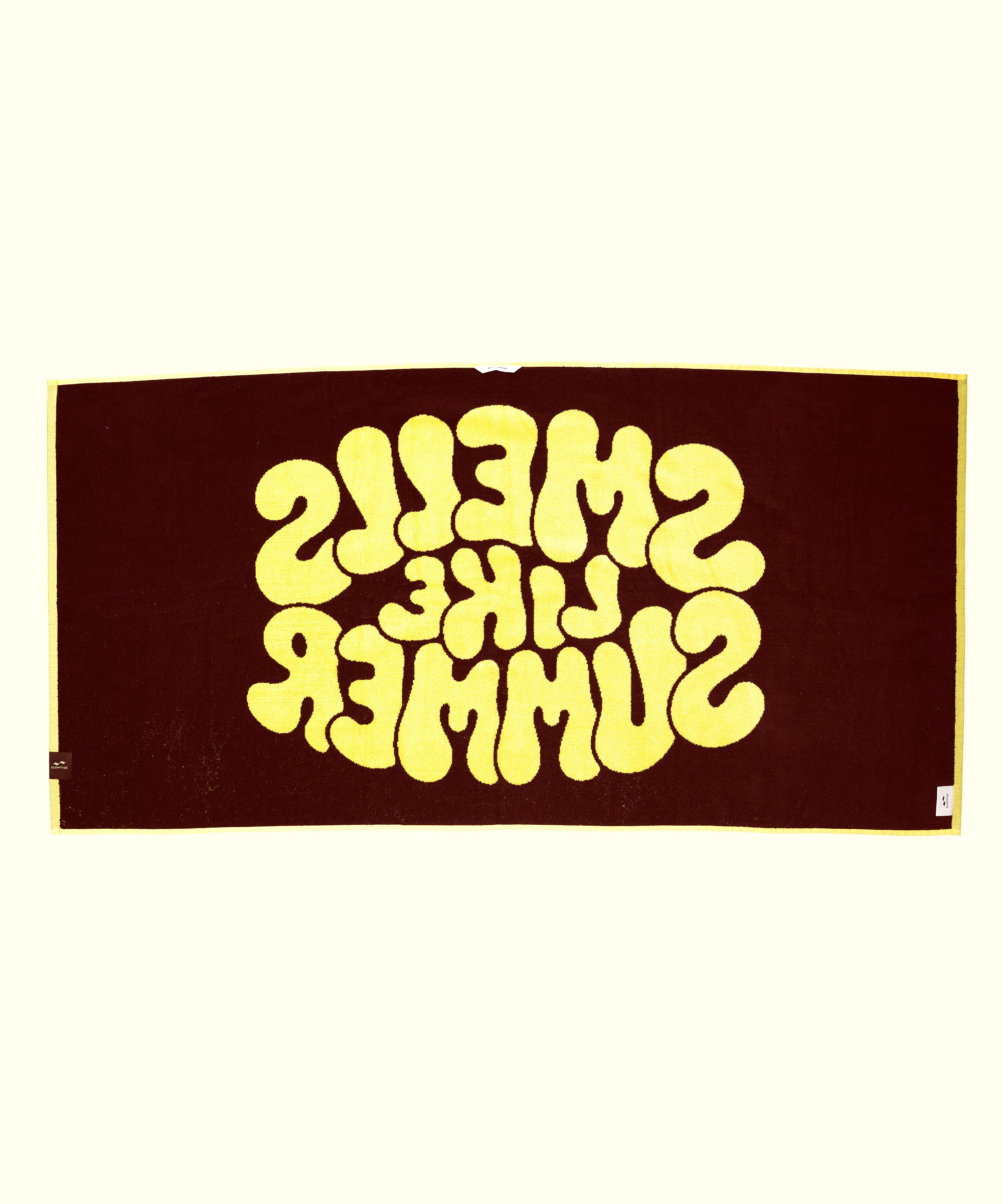 Textile with 'SMELLS LIKE SUMMER' printed in yellow on a brown background