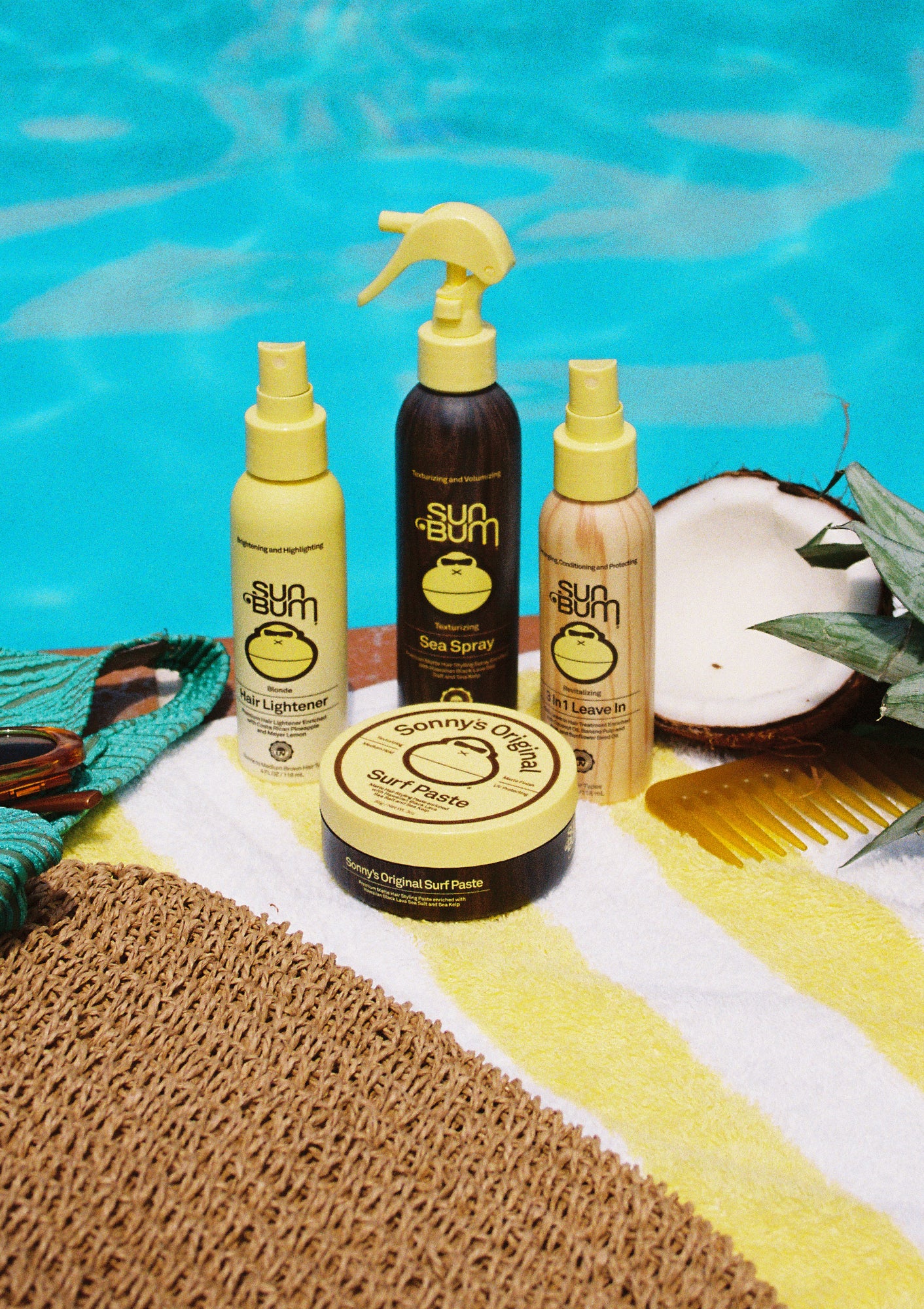 Sunscreen products on a towel by a pool