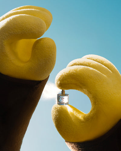 Close-up of a lemon with a small metal object inside against a clear blue sky.