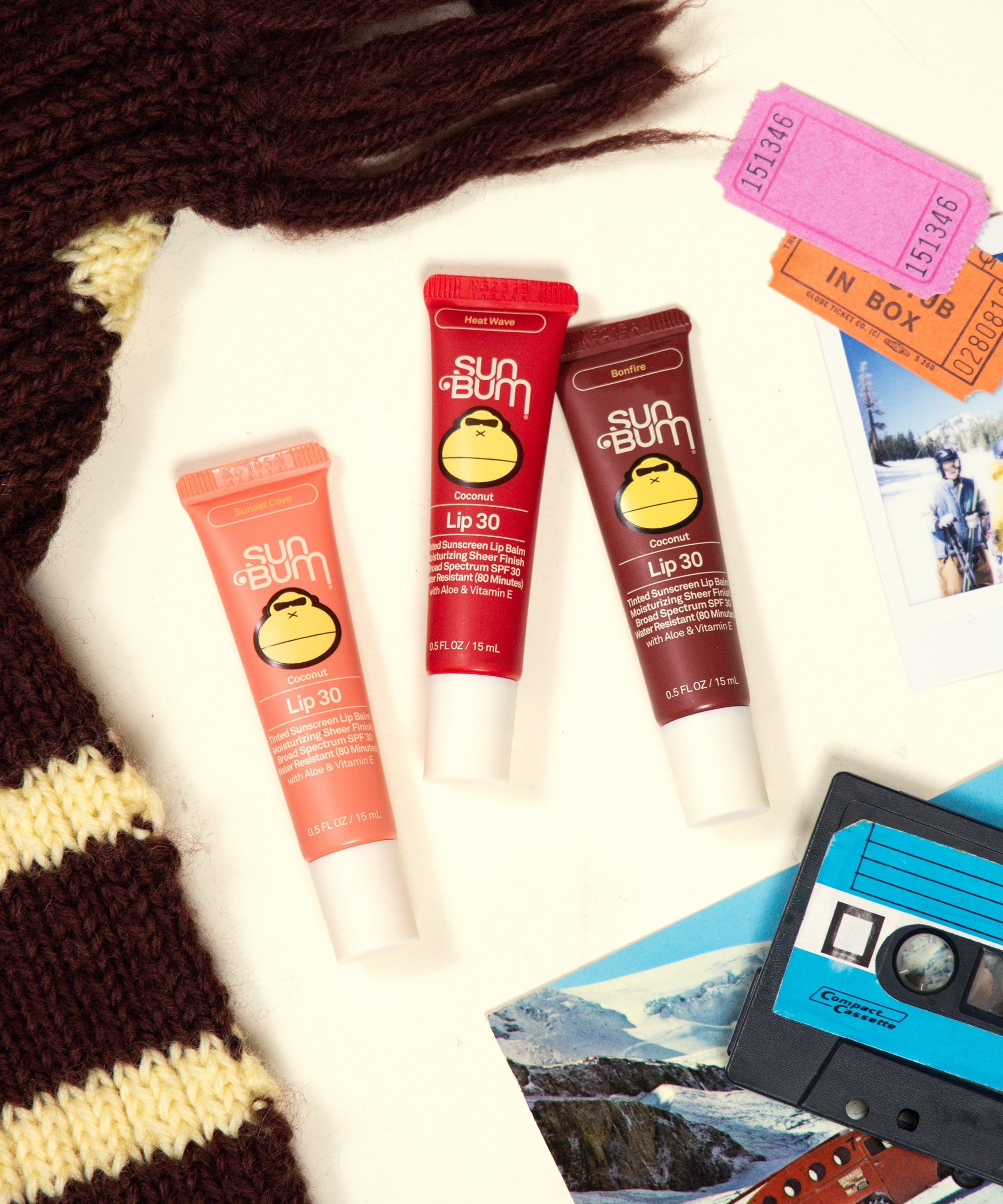 Sun Bum lip balm tubes with a cassette tape and photos on a white background