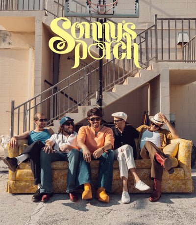 Album cover for 'Sunny Porch' featuring five men sitting on a yellow floral armchair in front of an outdoor staircase of a beige building. The title 'Sunny Porch' is written in a large, stylized yellow font at the top.