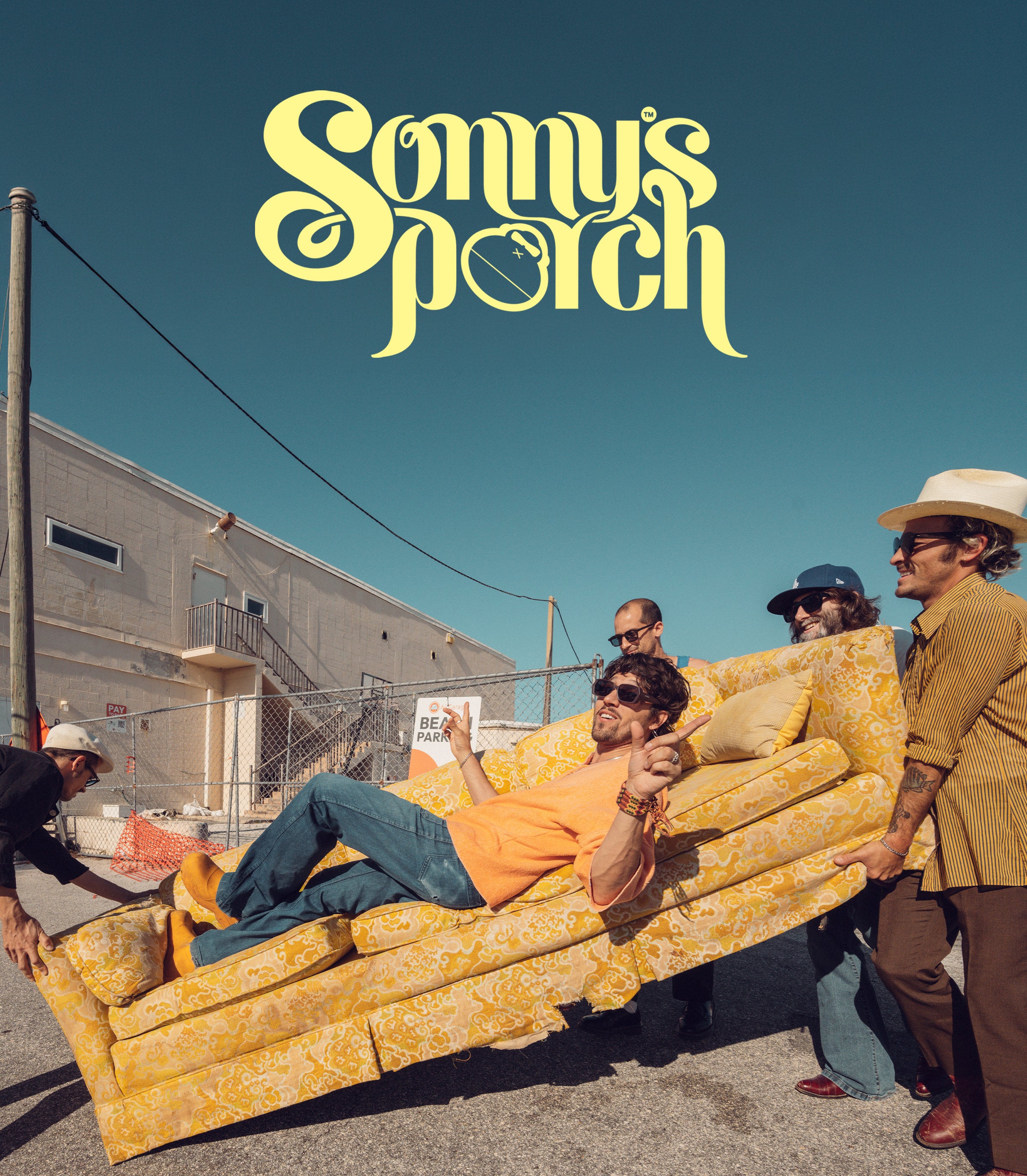 Album cover art for 'Sonny's Porch' featuring a group of people carrying a yellow patterned couch in an outdoor industrial setting under a clear blue sky, with the stylized yellow title text at the top.