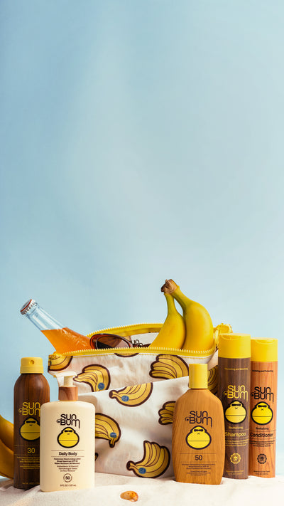 Sunscreen bottles and a bag with banana design on a light blue background