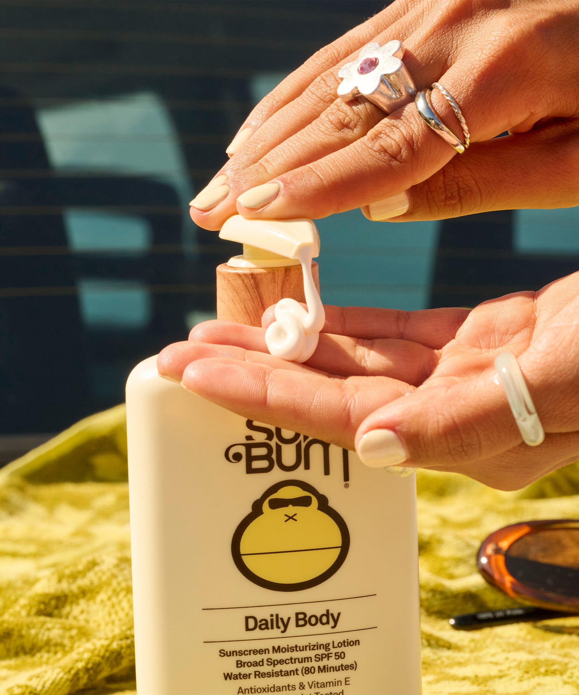 Sun Bum Daily 50 Body + Face 50 Lotion being dispensed, showing creamy SPF 50 sunscreen moisturizer with antioxidants.
