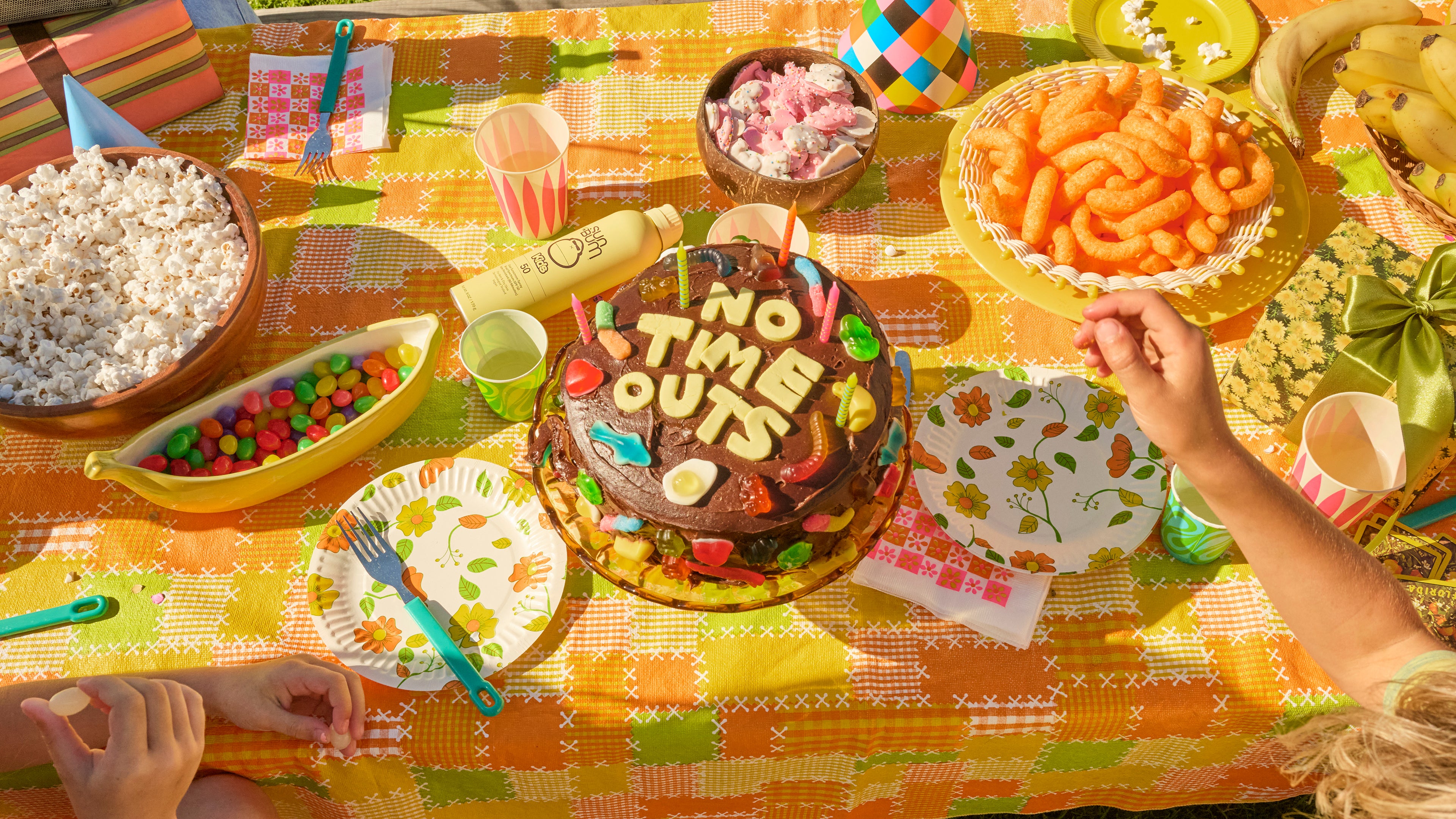 Colorful birthday party setup with a cake, snacks, and decorations on a table.