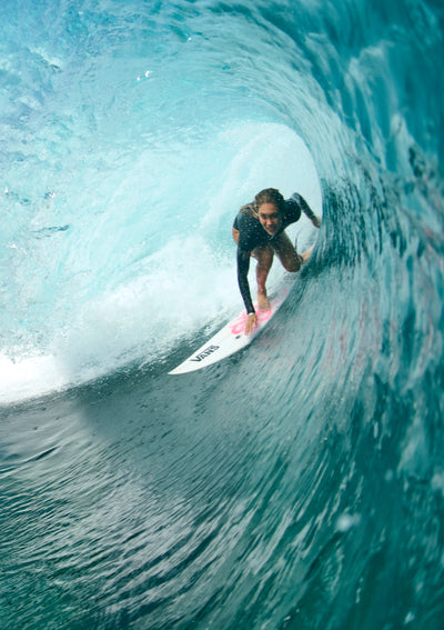 A woman surfing in a bug barrel wave
