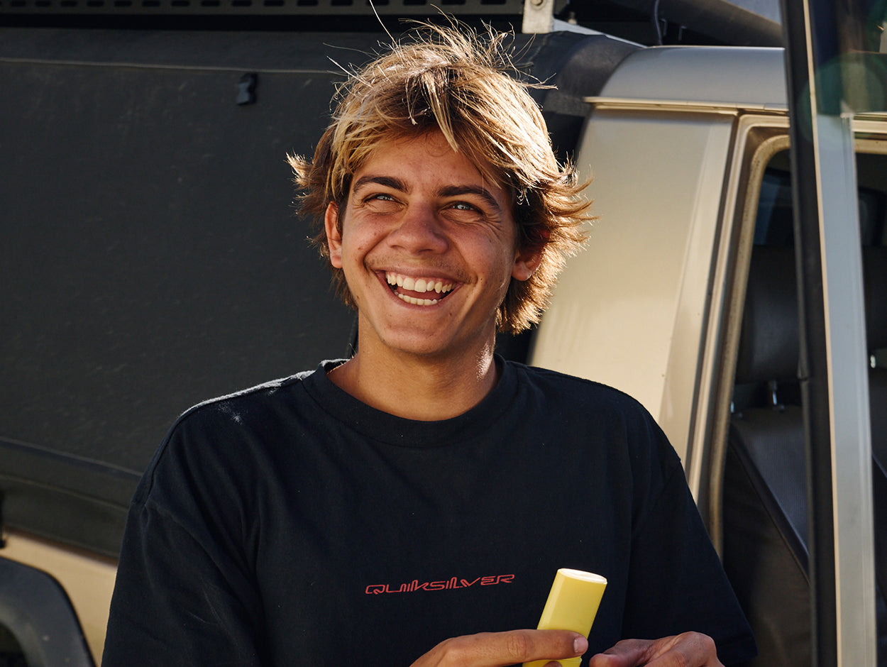 Person holding a yellow object in front of a vehicle