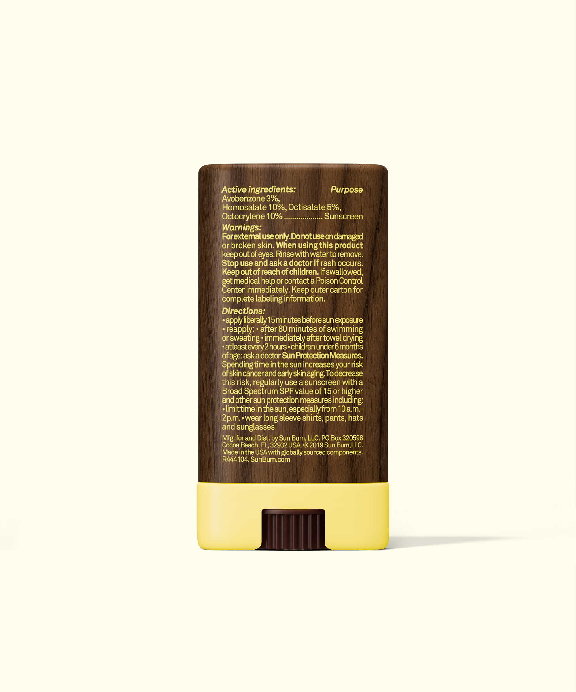 Skincare stick with brown top and yellow bottom on a white background