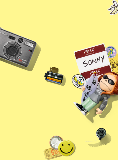 Camera accessories and figurine on a yellow background
